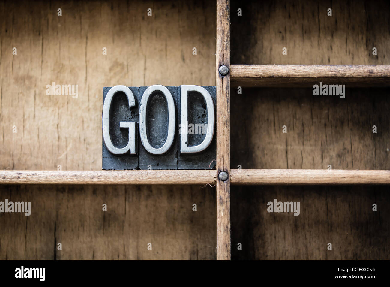 The name 'GOD' written in vintage metal letterpress type sitting in a wooden drawer. Stock Photo