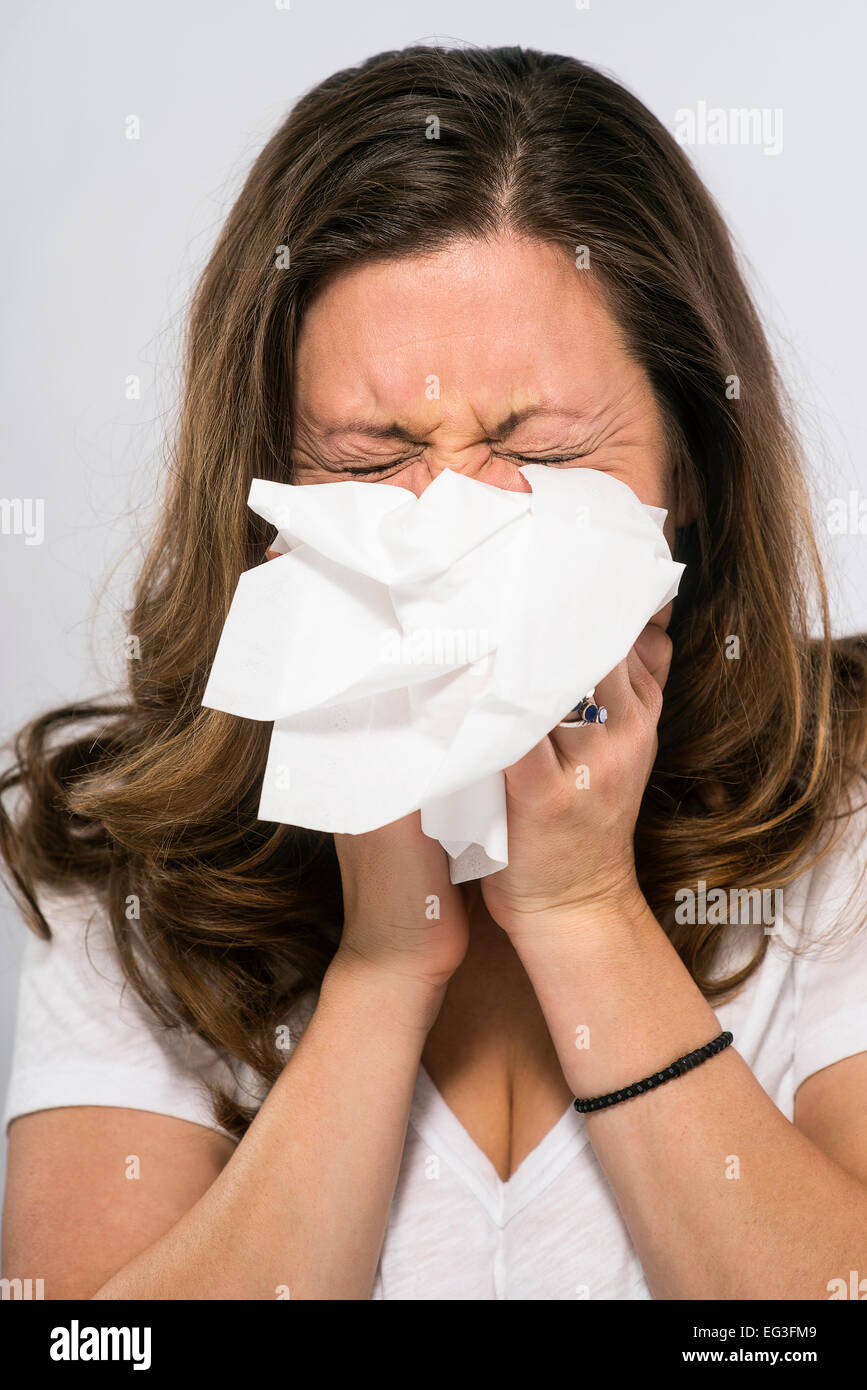A woman sneezing Stock Photo