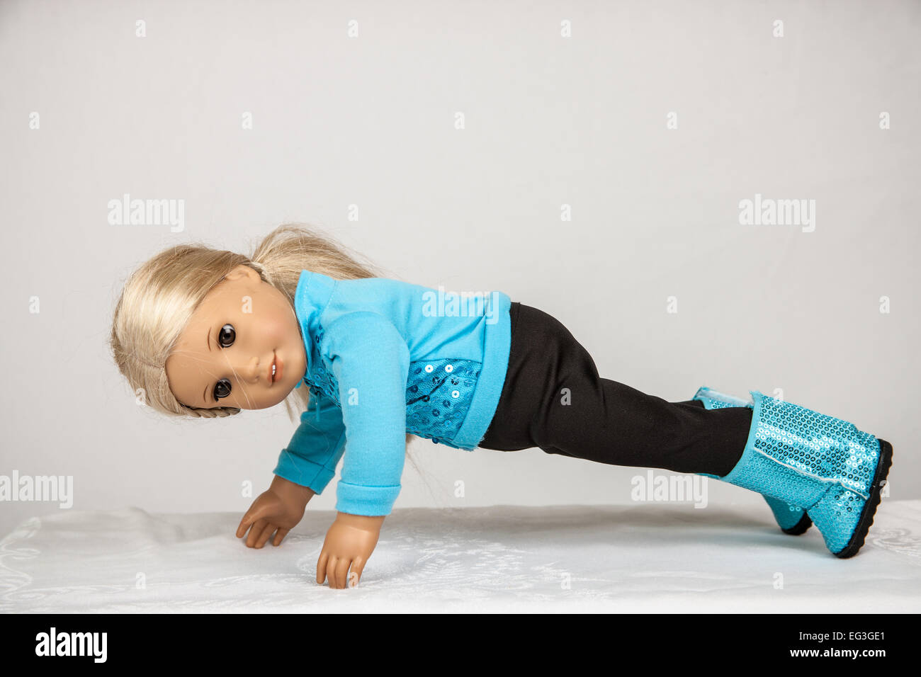 American Girl doll in her workout clothes doing push-ups Stock Photo