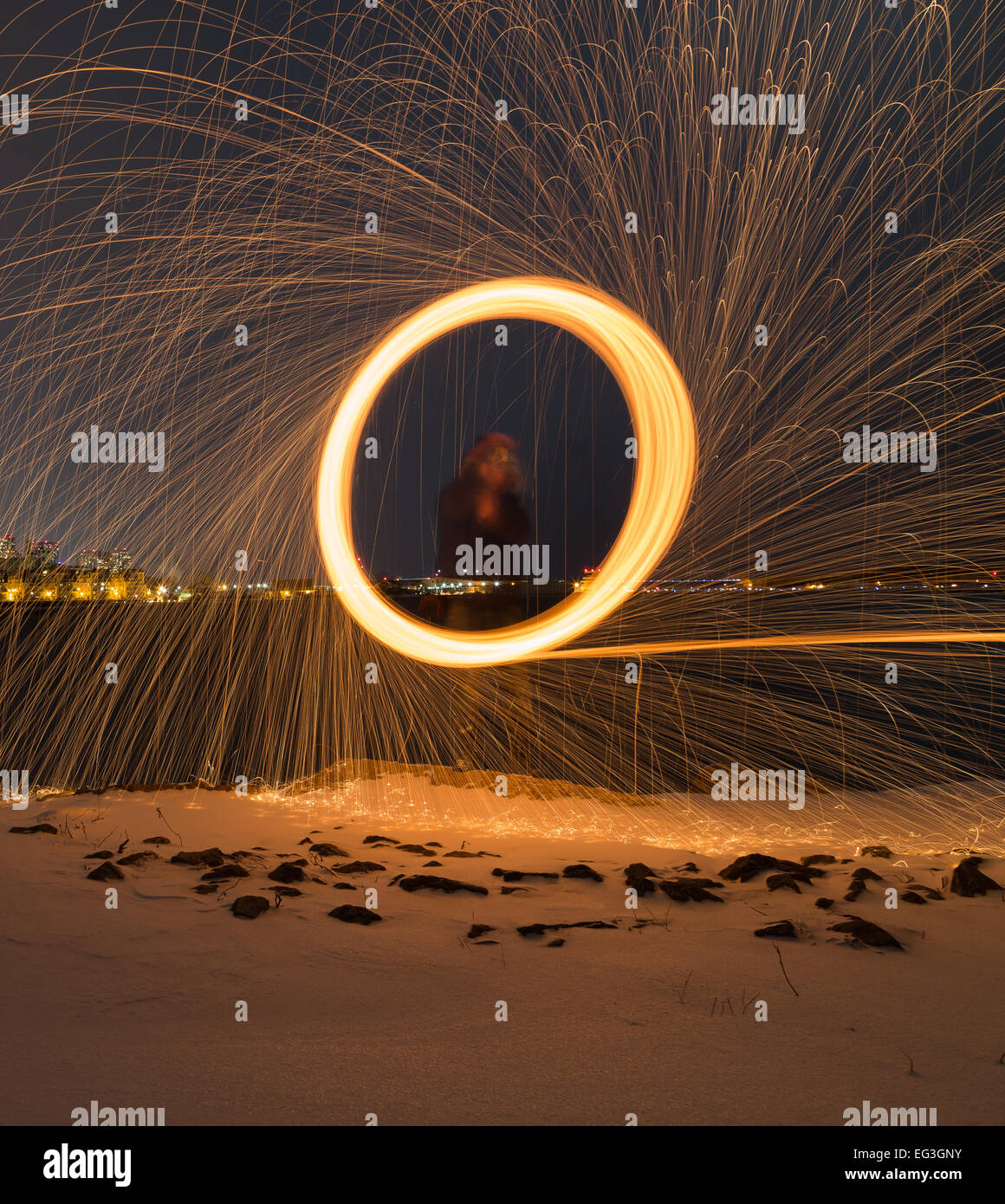 A man spinning wool outside at night with copyspace at the bottom Stock Photo