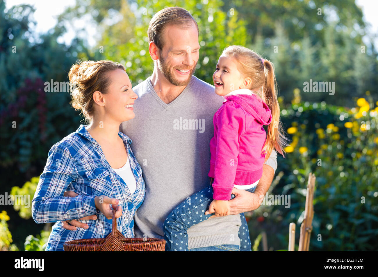 Mother, father and daughter in garden Stock Photo