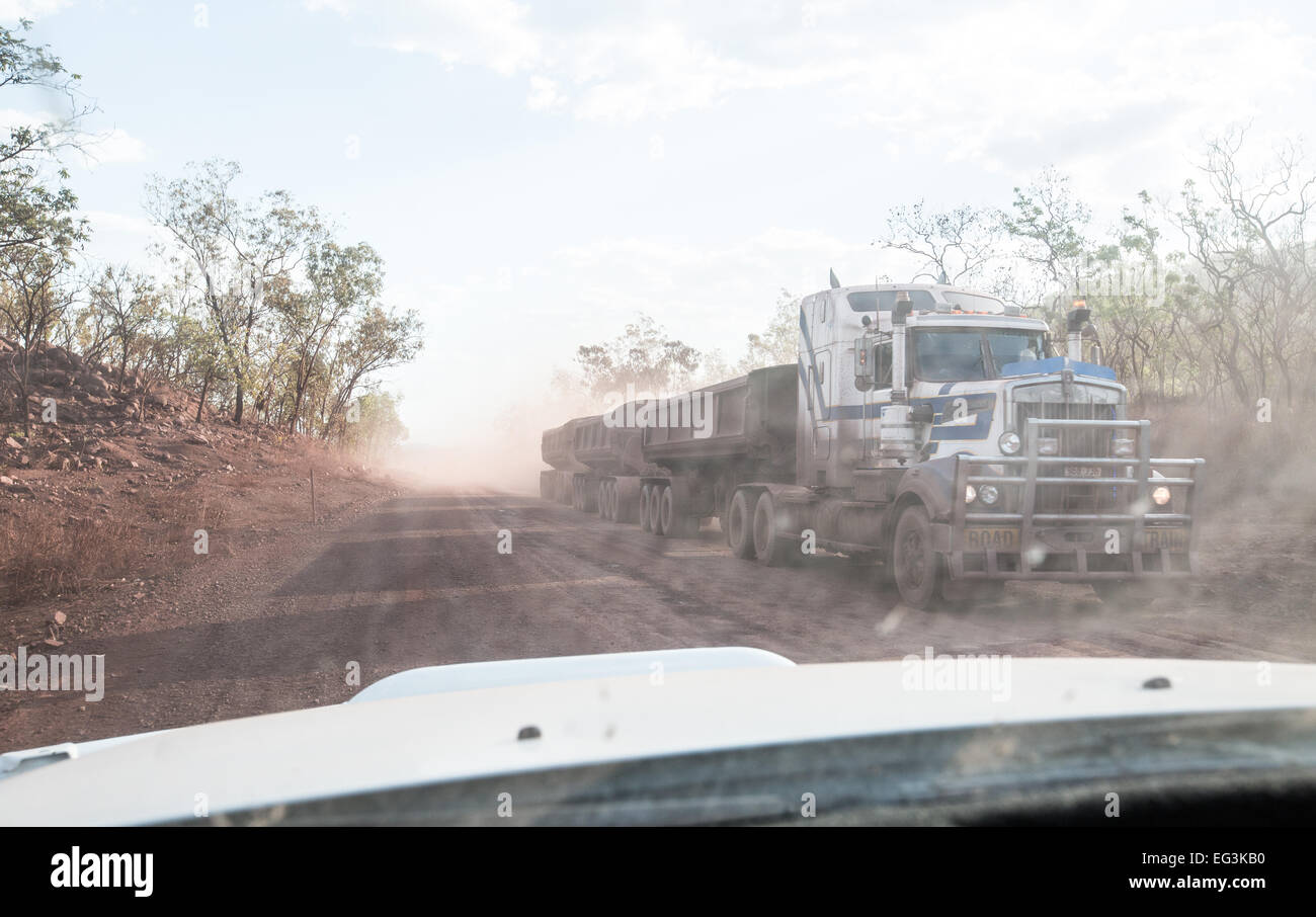 Road train thundering along outback road, Australia Stock Photo
