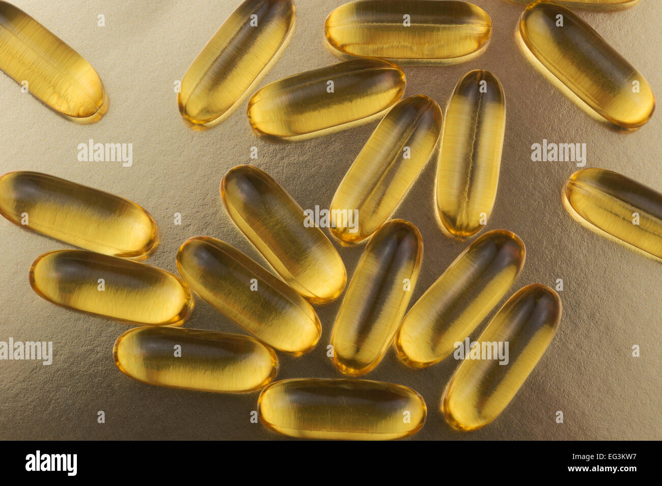 Omega 3 fish oil supplements on gold background Stock Photo