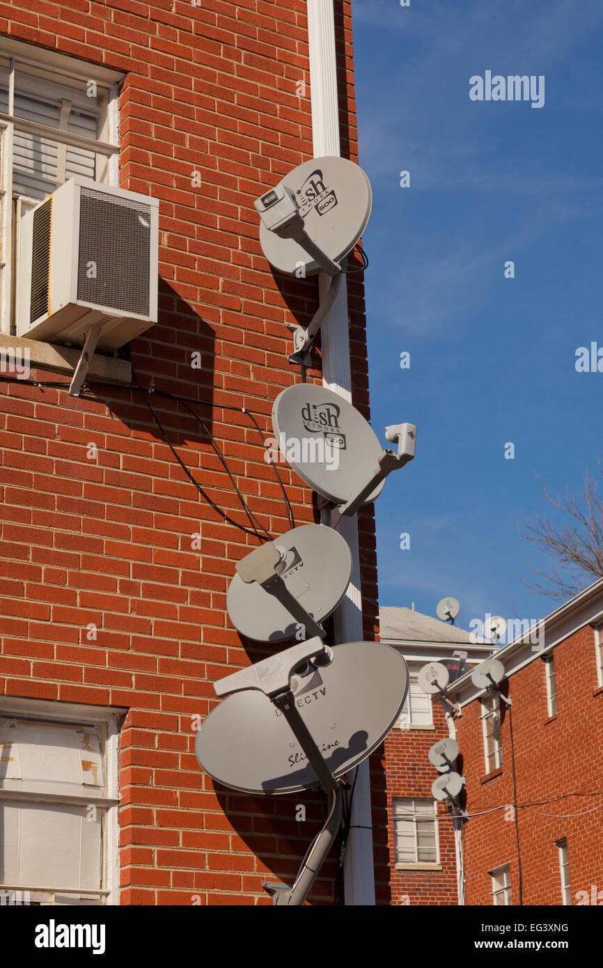 TV satellite dishes mounted on exterior of apartment building - Virginia USA Stock Photo
