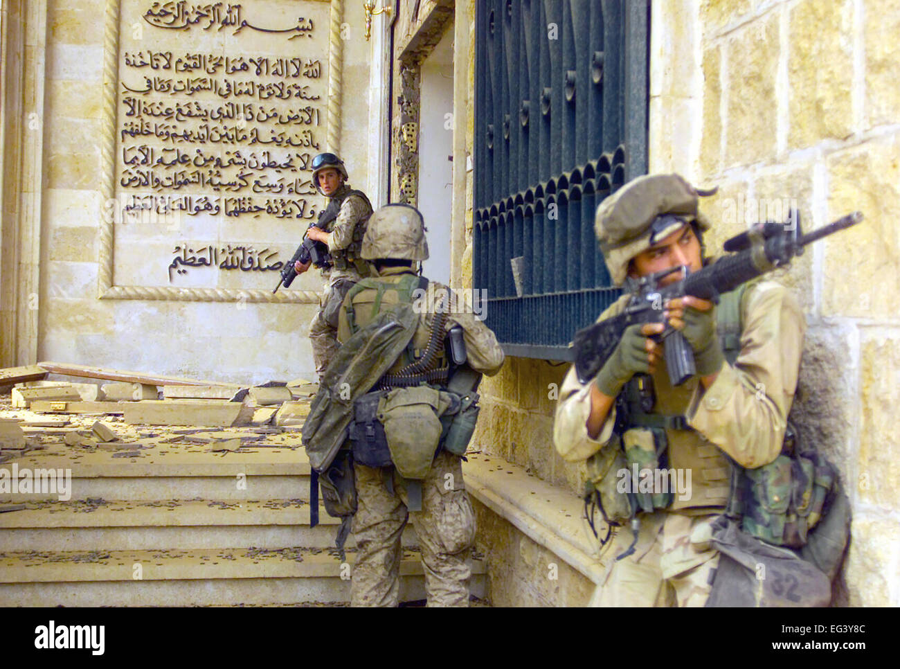 US MARINE CORPS Marines from the 1st Battalion, 7th Marines (1/7), Charlie Company, Twentynine Palms, California (CA), cover each other with 5.56 mm M16A2 assault rifles as they prepare to enter one of Saddam Hussein’s palaces in Baghdad as they takeover the complex during Operation IRAQI FREEDOM in April 2003. Stock Photo