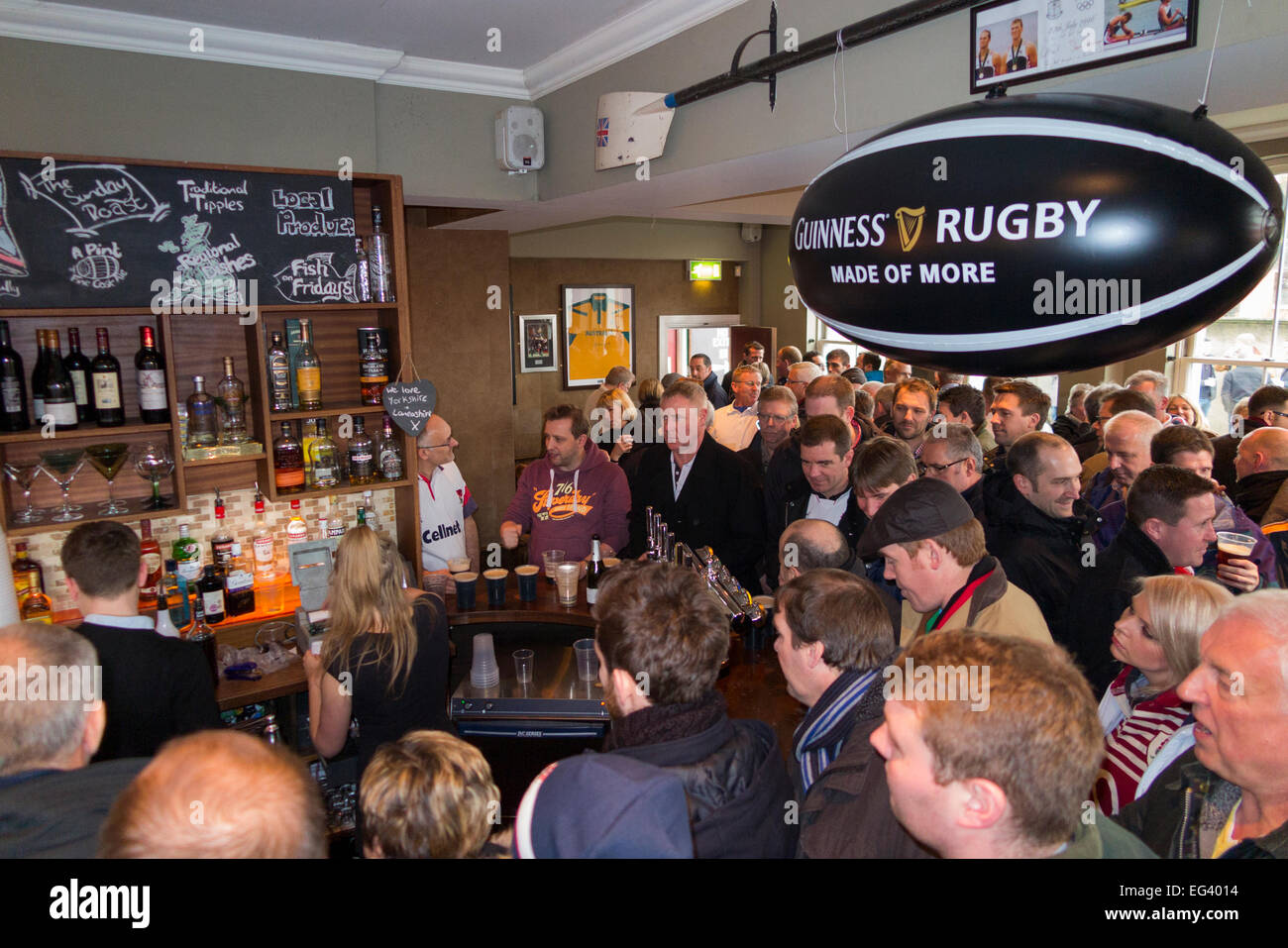 Rugby fan fans wait for barman man barmaid / staff at busy The Albany pub / public house. Twickenham UK; popular match days. Stock Photo