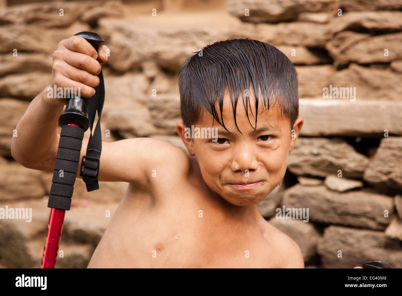 Young Nepali kid posing with arekking pole Stock Photo