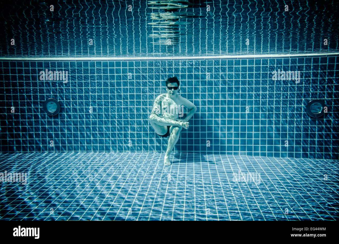 Man sitting on the bottom of the swimming pool under water Stock Photo ...