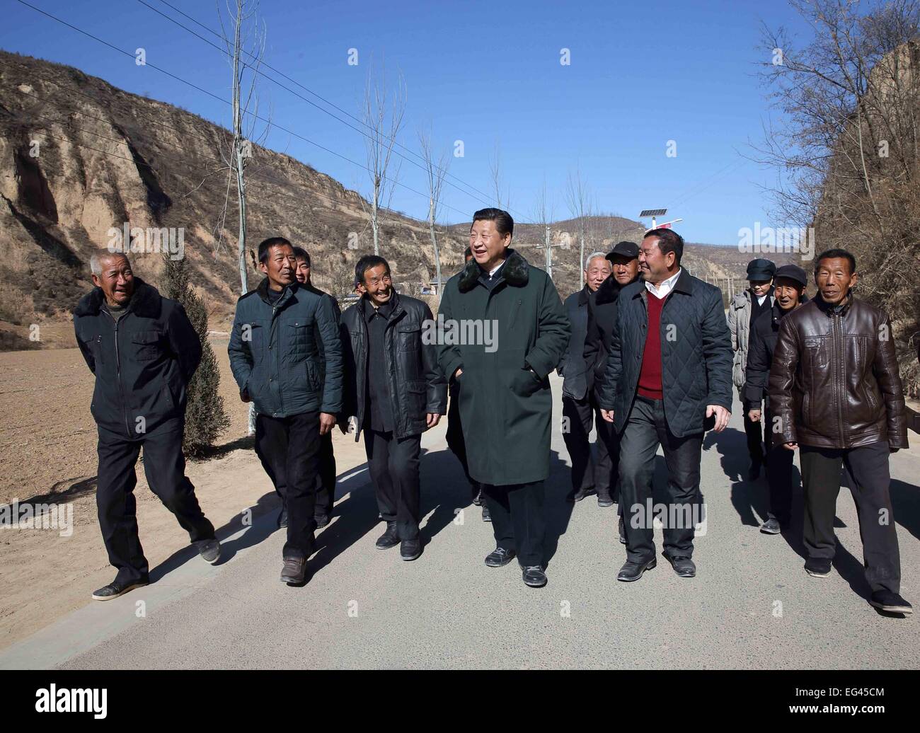 Xi'an, China's Shaanxi Province. 13th Feb, 2015. Chinese President and General Secretary of the Communist Party of China Central Committee Xi Jinping (C), also chairman of the Central Military Commission, visits people in Liangjiahe Village, Wen'anyi Township of Yanchuan County, Yan'an, northwest China's Shaanxi Province, Feb. 13, 2015. Xi made a tour in Shaanxi on Feb. 13 - 16, and extended festival greetings to locals and people across the nation ahead of the Spring Festival, which falls on Feb. 19. © Lan Hongguang/Xinhua/Alamy Live News Stock Photo