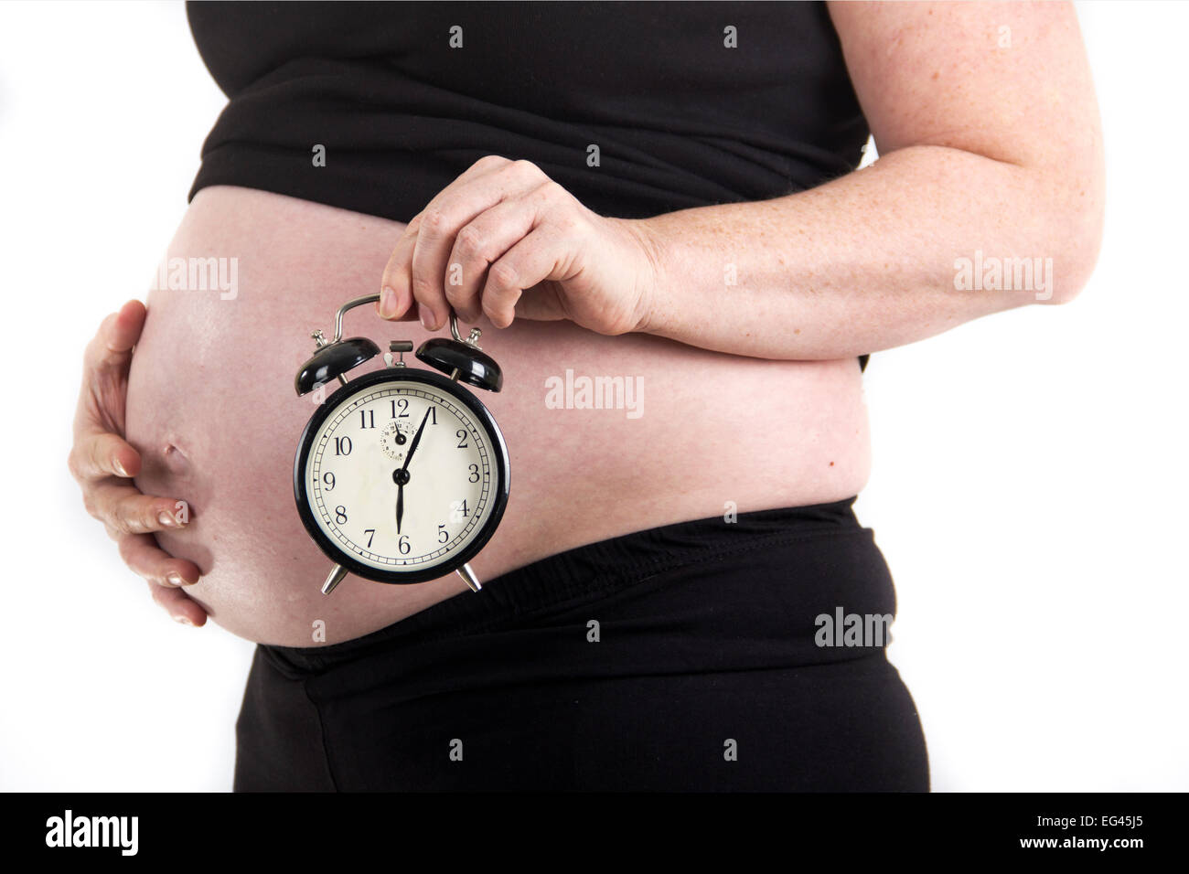 pregnant woman holding clock Stock Photo