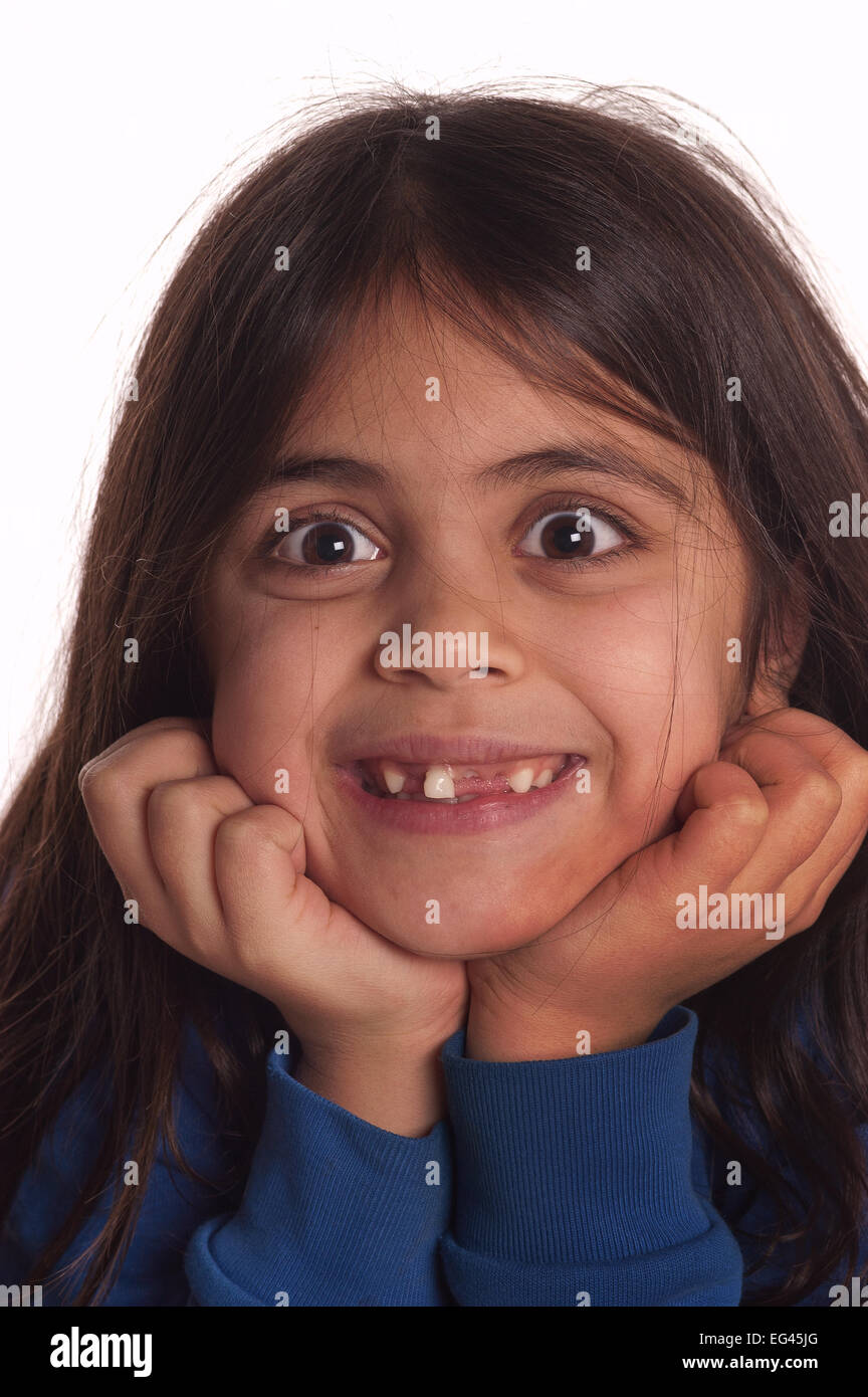 Seven year old girl happy growing up and fact about to loose last wobbly remaining front tooth milk teeth falling out Stock Photo