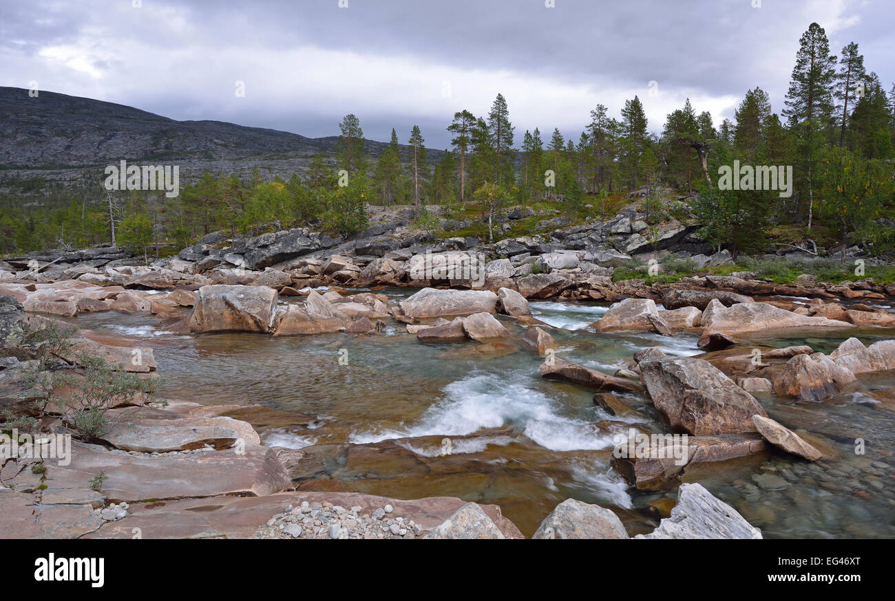 Rocks and stones in the RMuonosjåhkå mountain river in SaRMtdaRM, near the Arctic CircRMe, Norway Stock Photo