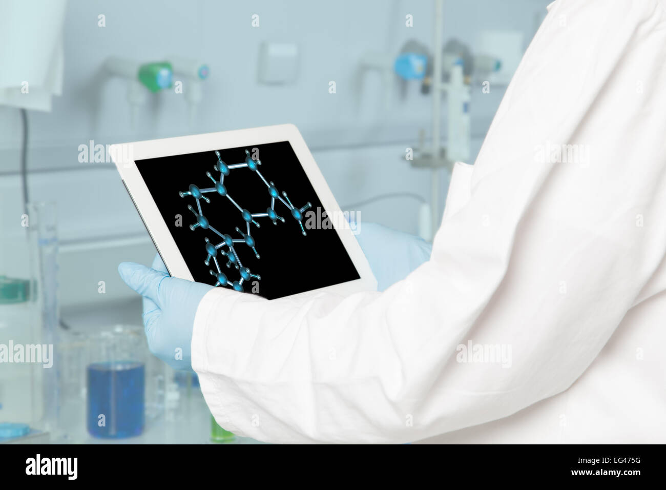 The Doctor is analysing a molecular structure on his tablet device. Stock Photo