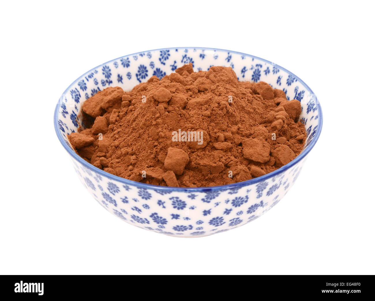 Cocoa powder in a blue and white porcelain bowl with a floral design, isolated on a white background Stock Photo
