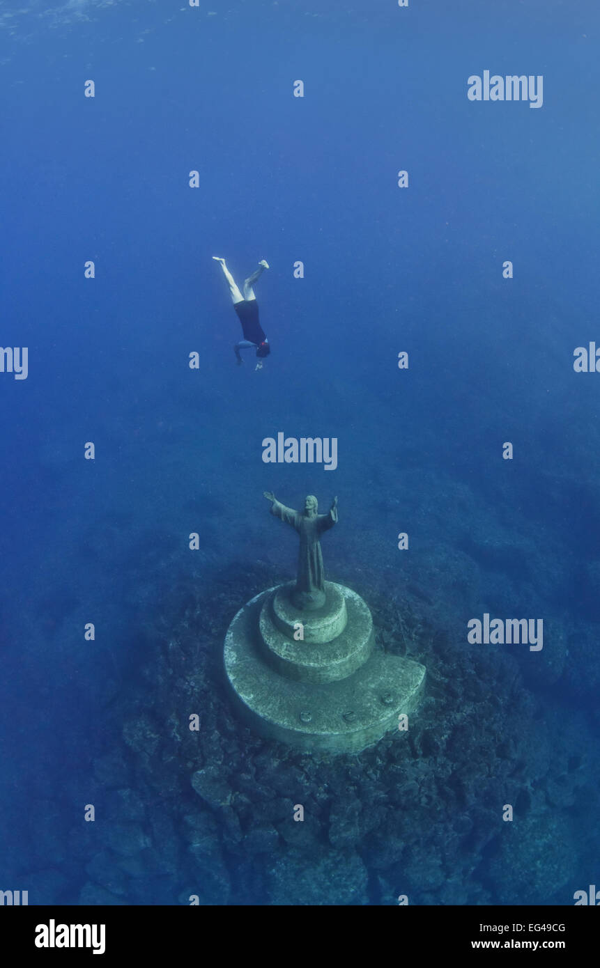 A fisherman swims down to touch the statue Christ The Abyss (Cristo