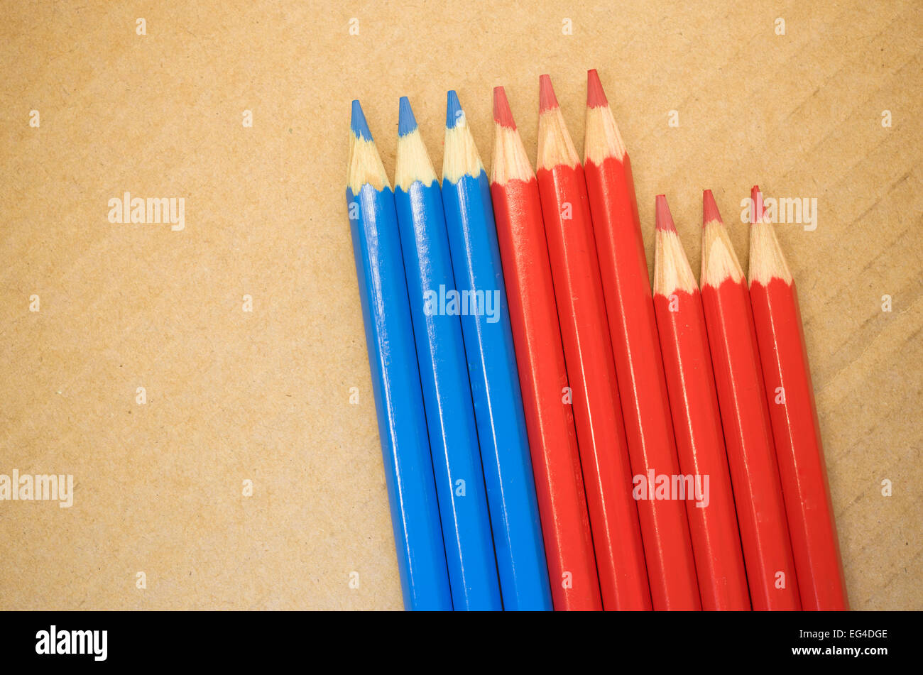 red blue colored crayons close up on a blurred light paperboard ...