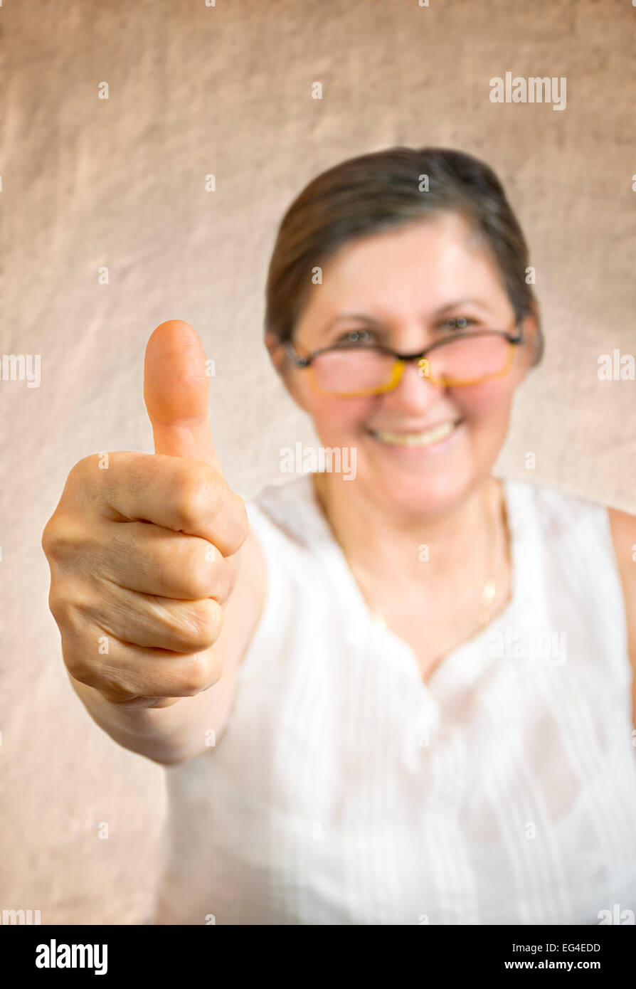 Happy woman showing thumb up.Approval or endorsement concept. Shallow DOF - finger in focus. Stock Photo