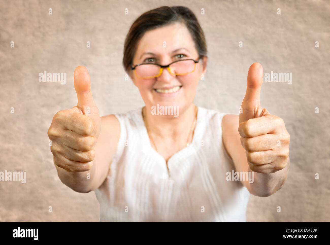Happy woman showing thumb up.Approval or endorsement concept. Shallow depth of field - finger in focus. Stock Photo