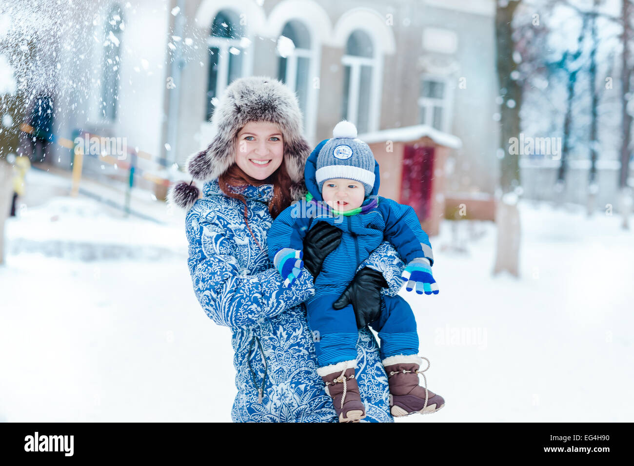 Happy mother and baby playing on snow in winter park Stock Photo - Alamy