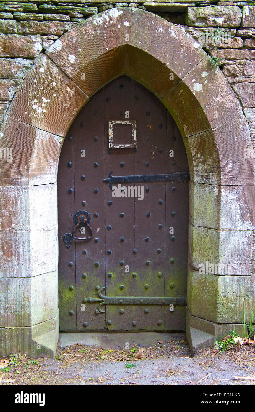 Fortified door studded with iron nails. Brougham Hall Penrith Cumbria England UK Stock Photo