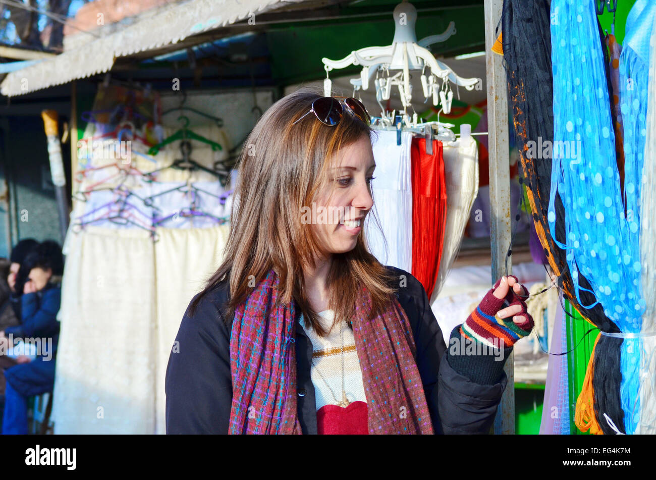 Young brunette looking at scarfs at an open air market Stock Photo