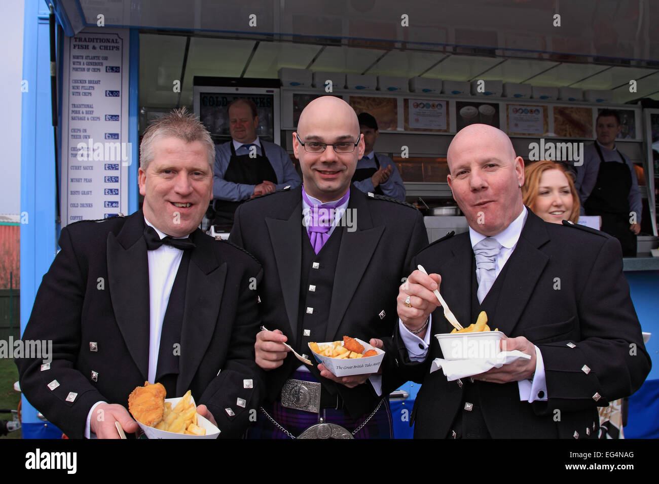 Three Scots from near Edinburgh tuck into fish and chips on Ladies Day / Grand National Meeting / Aintree Racecourse / Liverpool Stock Photo
