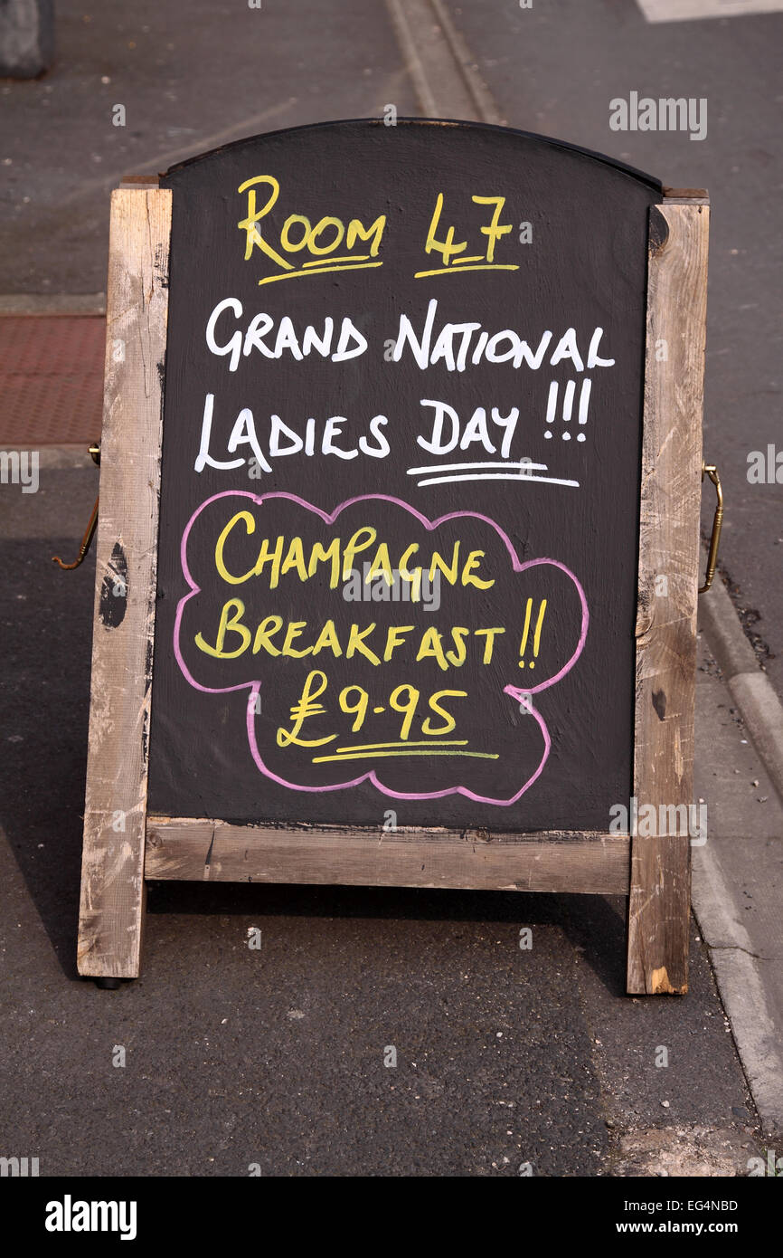 Board advertising Ladies Day champagne breakfast, close to Ormskirk railway station which connects directly with Aintree Stock Photo