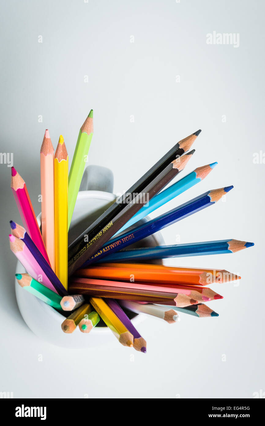A group of color pencils in a cup from a high angle in a white isolated background Stock Photo