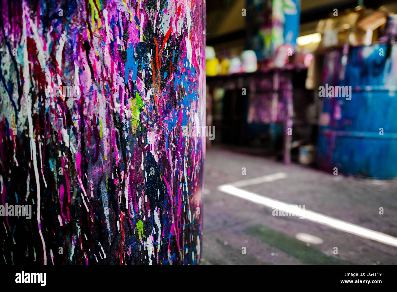 A plastic barrel, splattered with colorful paint, is seen in a small scale bicycle factory in Cali, Colombia. Stock Photo
