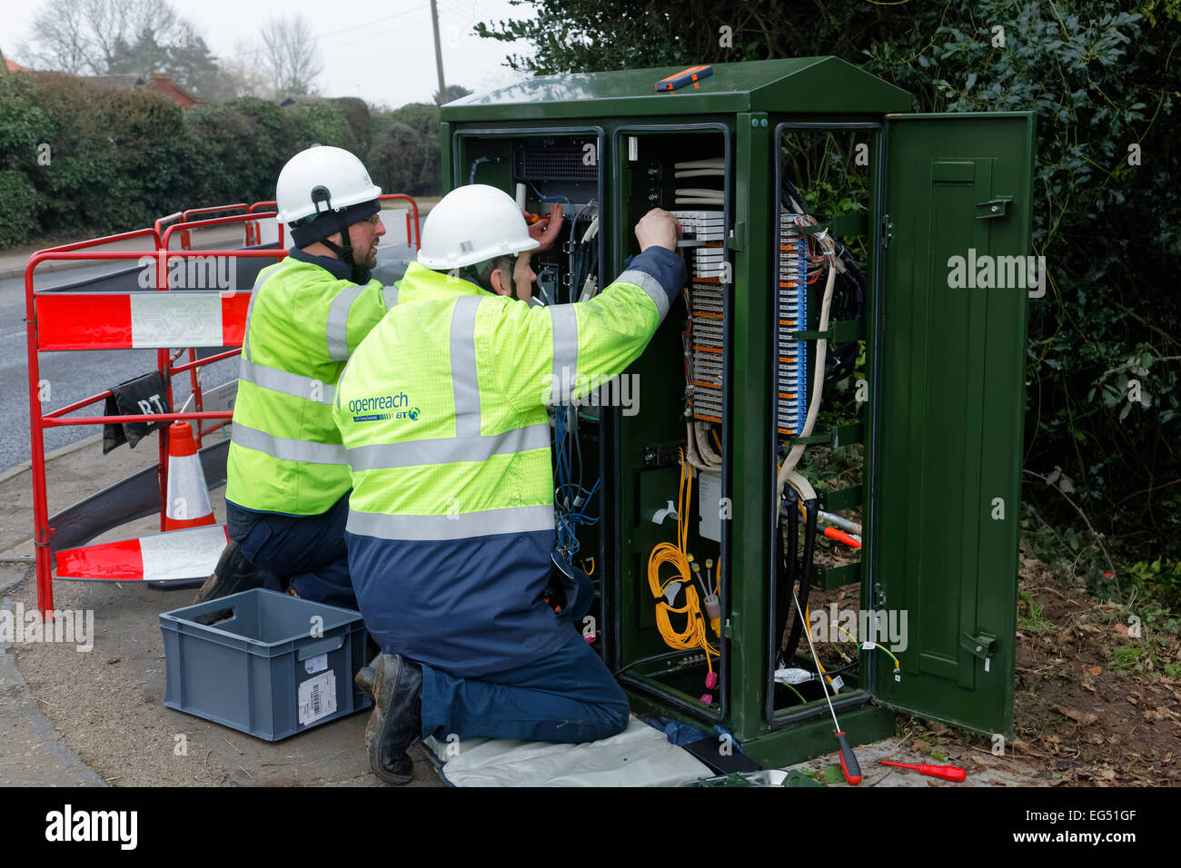 BT Openreach engineers working on a broadband internet fibre cabinet in the street Stock Photo