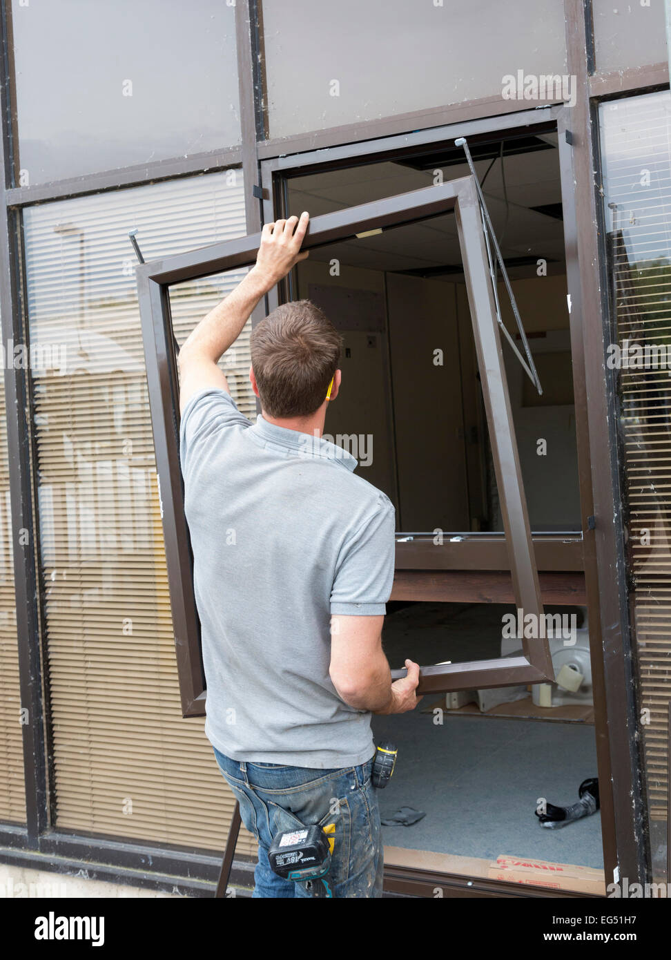 worker installing window frames / replacement glass Stock Photo Alamy