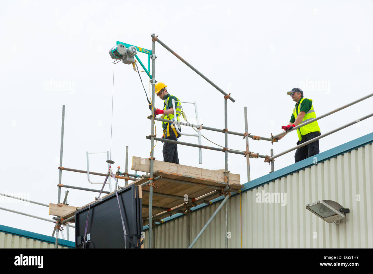 workers using an electric hoist on a construction site Stock Photo Alamy