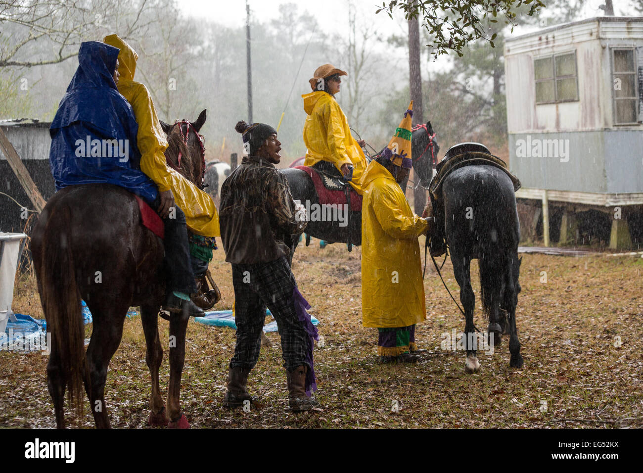 Costumed horse riders prepare to mount in pouring rain during the ...