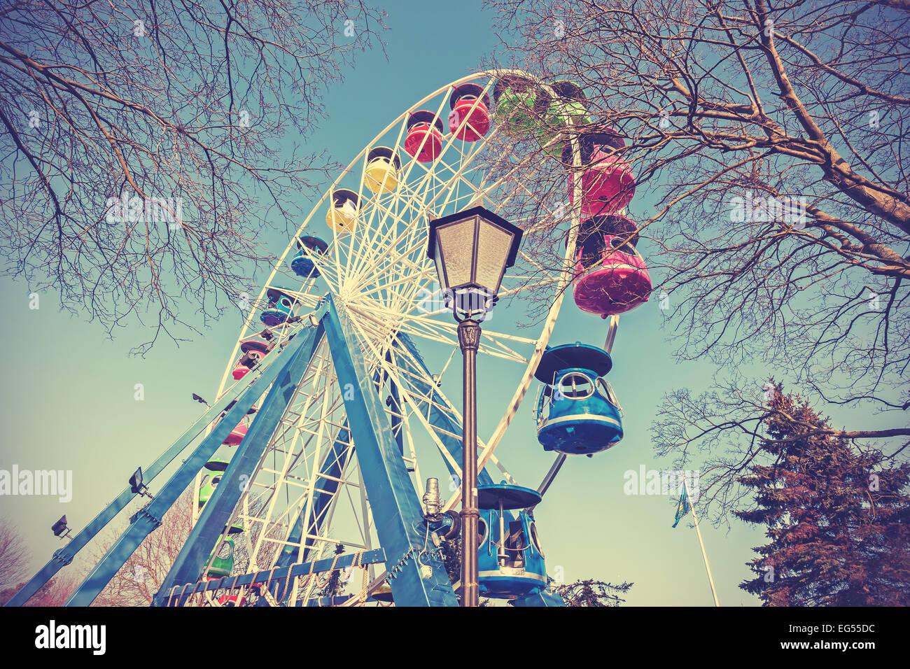 Retro filtered picture of ferris wheel in a park. Stock Photo