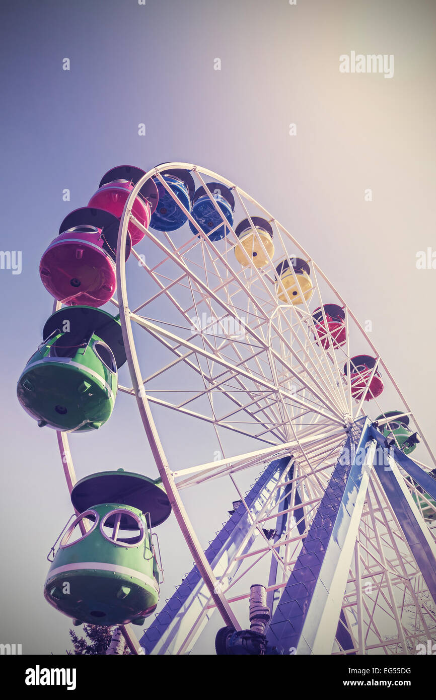 Retro filtered picture of ferris wheel in a park. Stock Photo