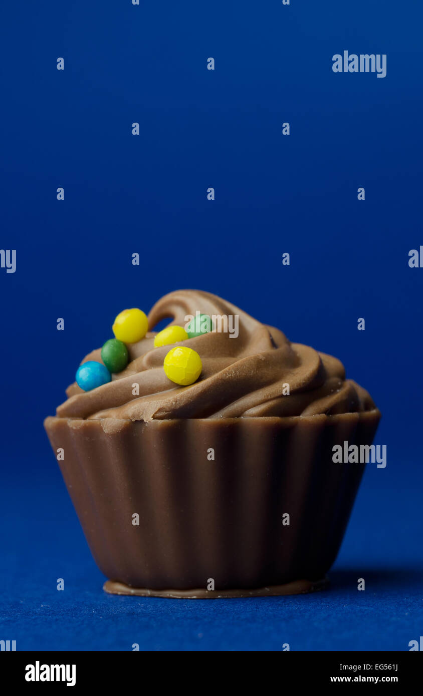 Single Chocolate Cup Cake over dark blue background Stock Photo