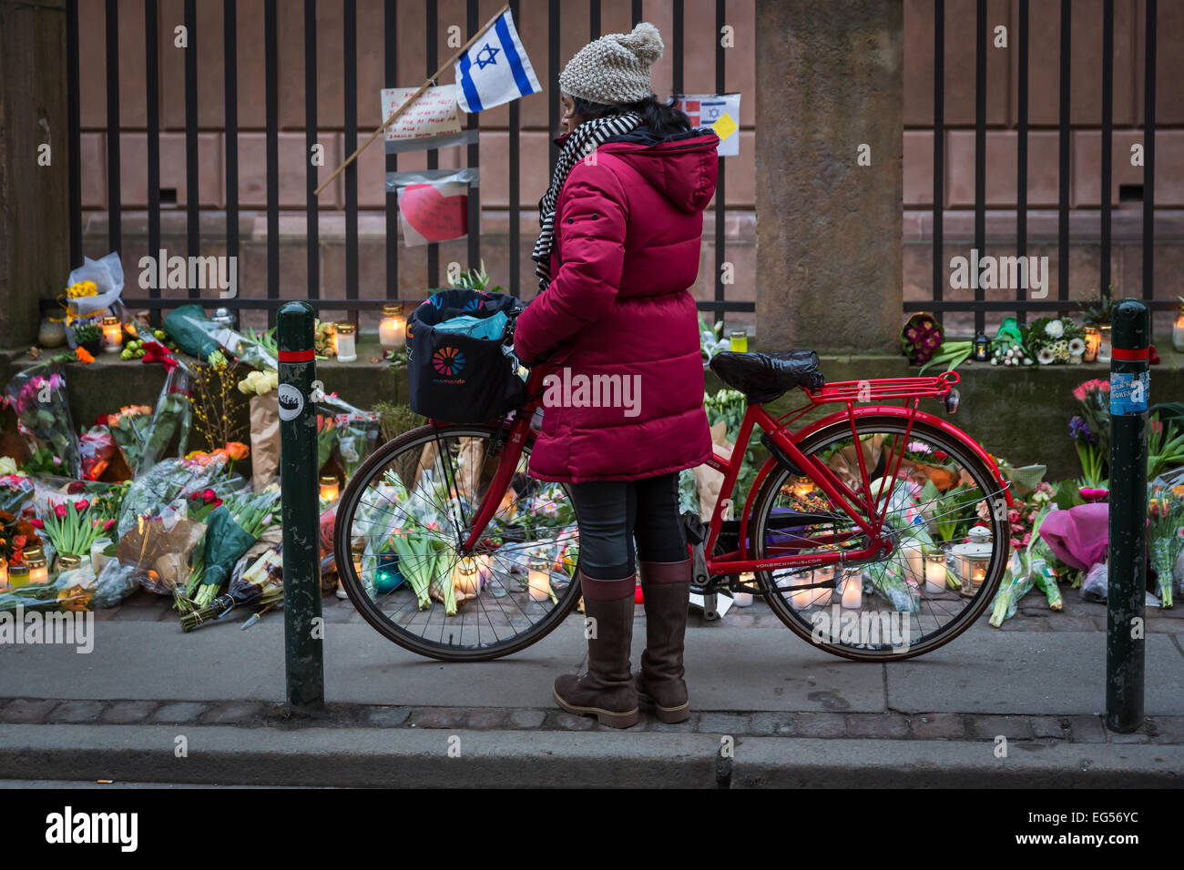 A woman watching the flowers at Copenhagen's main synagogue where a man was killed during a terrorist attack on 15 February 2015 Stock Photo
