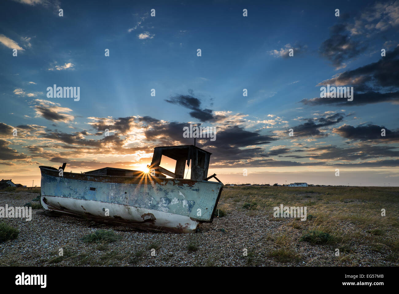 Abandoned fishing boat on shingle beach landscape at sunset Stock Photo ...