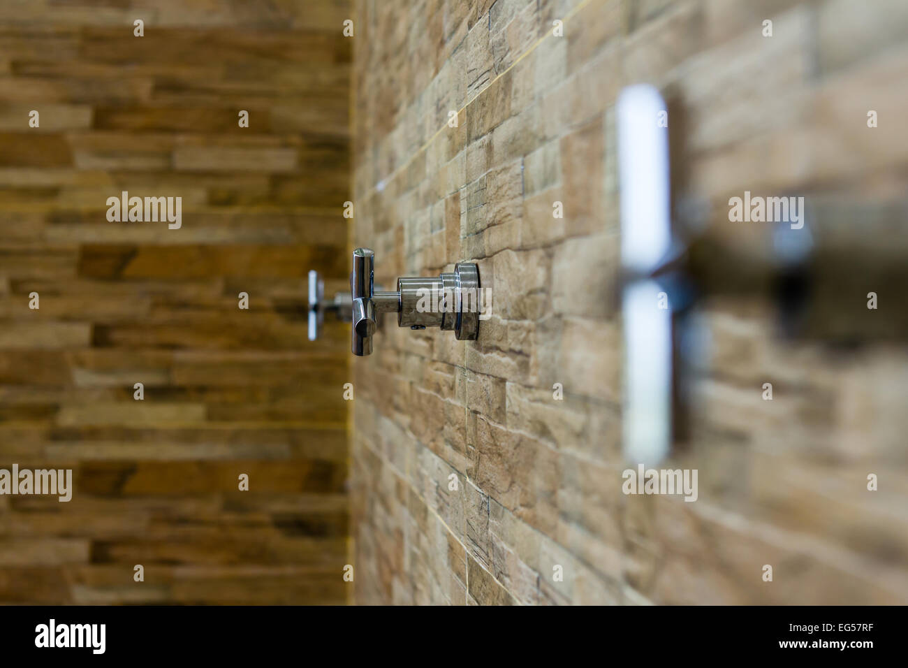 The faucet on the brick wall background (select focus) Stock Photo