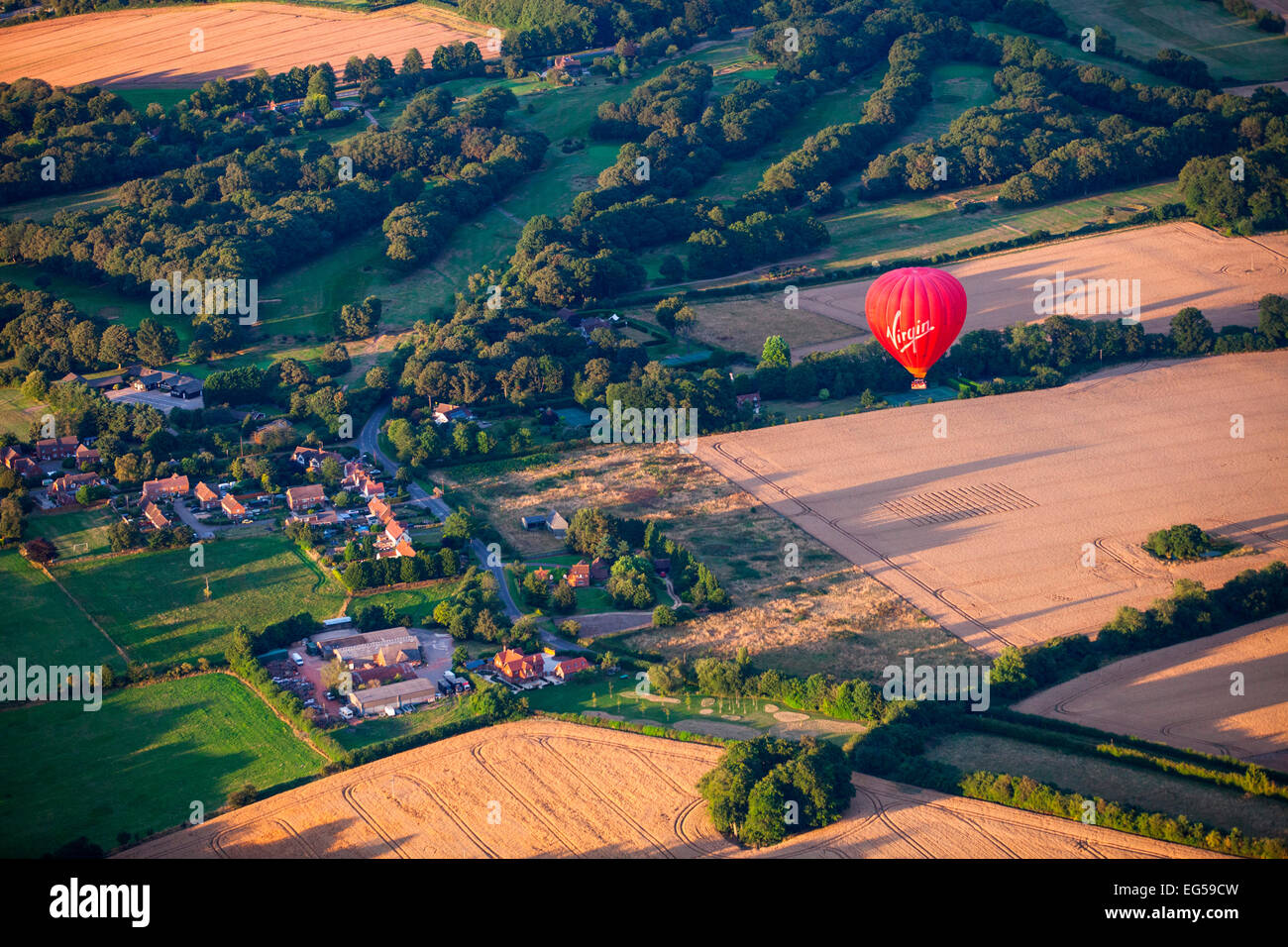 Aerial view of red hot air balloon flying over rural landscape, South Oxfordshire, England Stock Photo