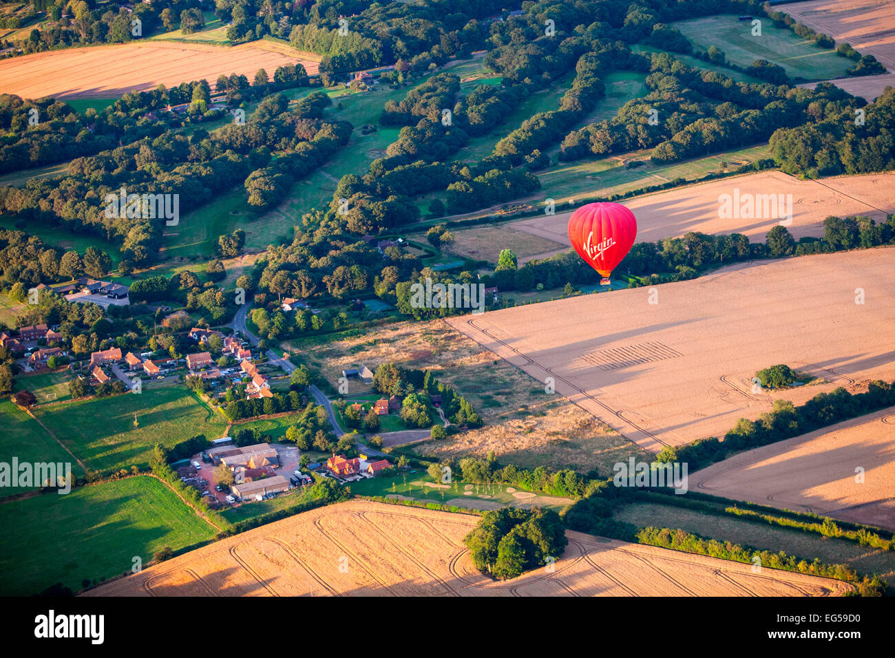 Aerial view of red hot air balloon flying over rural landscape, South Oxfordshire, England Stock Photo