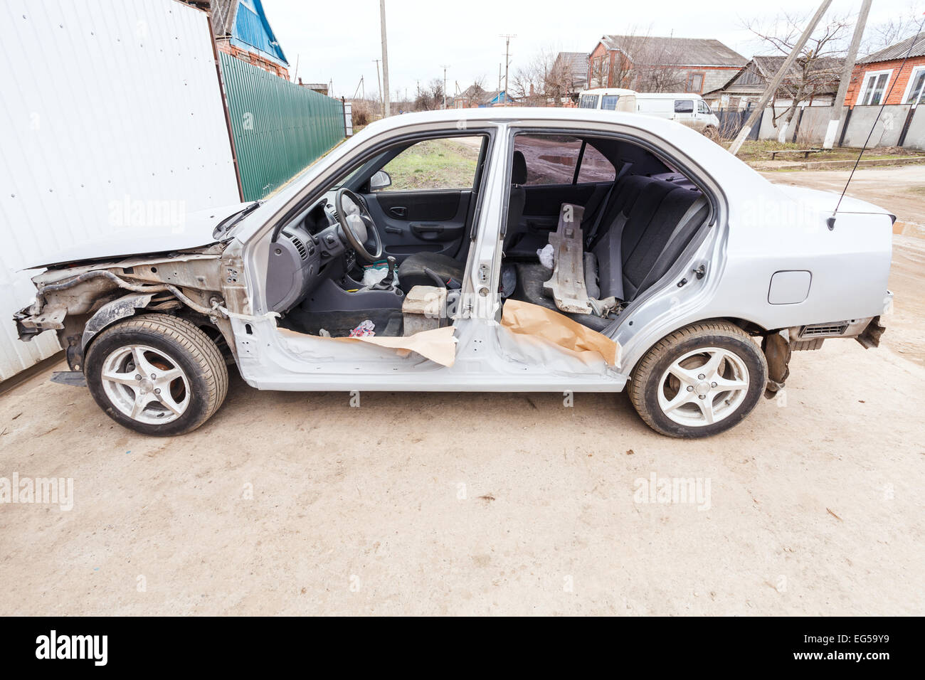 disassembled car near the garage door in village Stock Photo