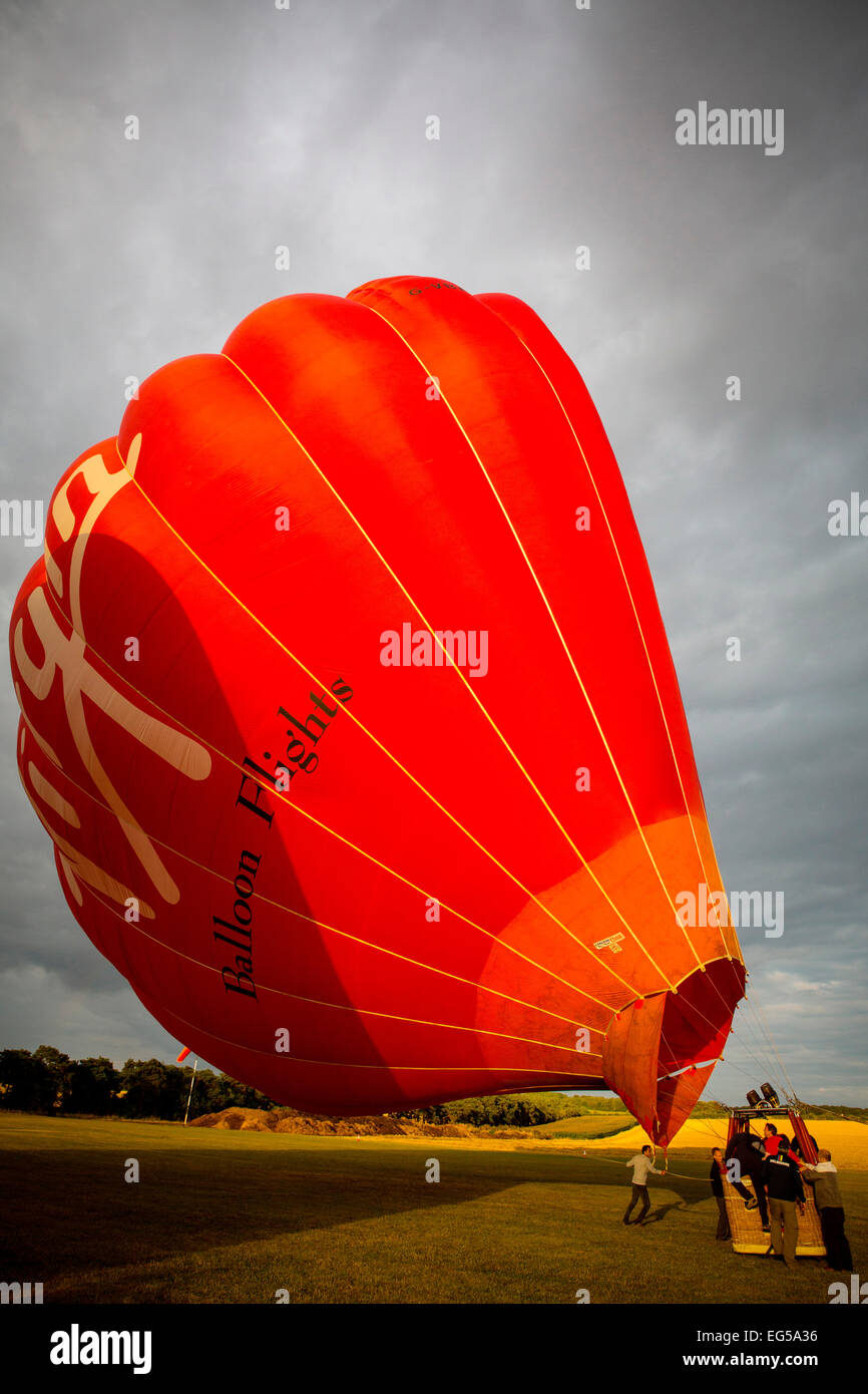 Teamwork preparation for tethered hot air balloon in field, South Oxfordshire, England Stock Photo