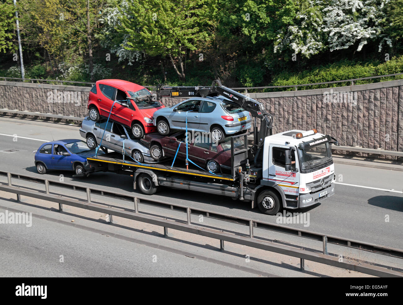 A scrap vehicle transport lorry on the A40 in West London, UK. Stock Photo