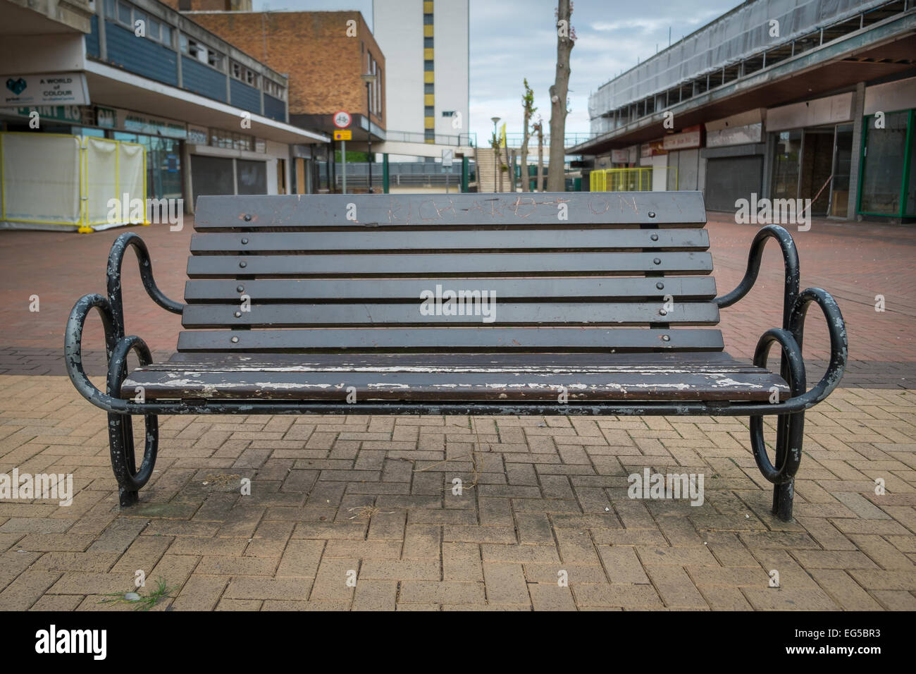 BRACKNELL, UK - AUGUST 11, 2013: A bench in an empty highstreet in the Berkshire town of Bracknell. Awaiting demolition to make Stock Photo