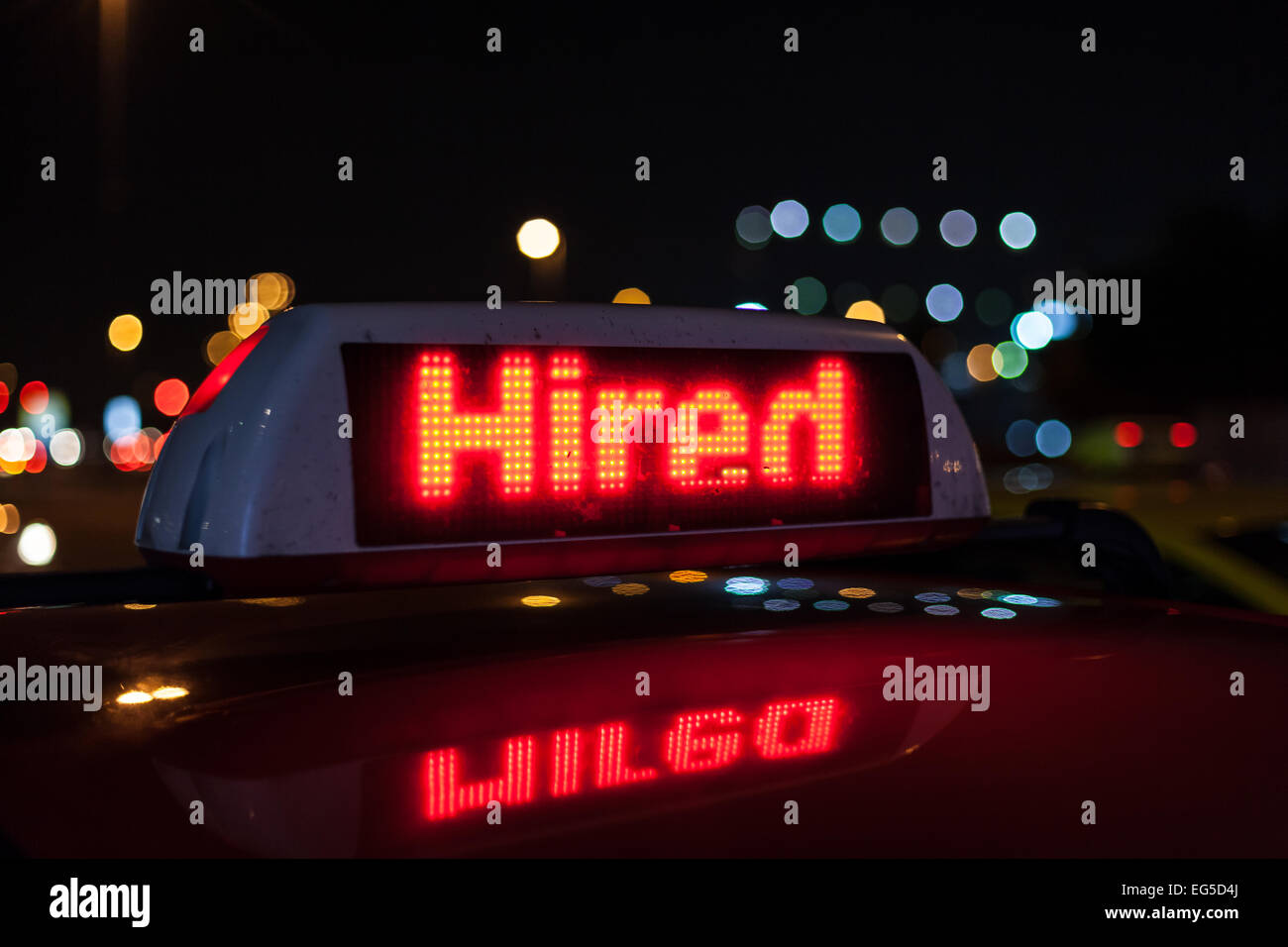 Hired taxi sign illuminated at night Stock Photo