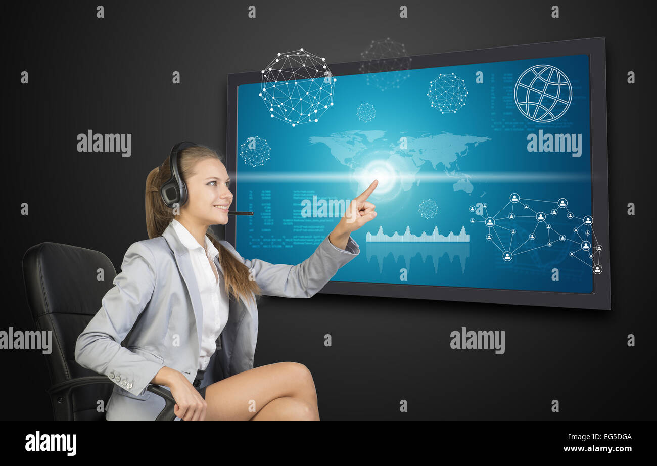 Businesswoman in headset using touch screen interface Stock Photo