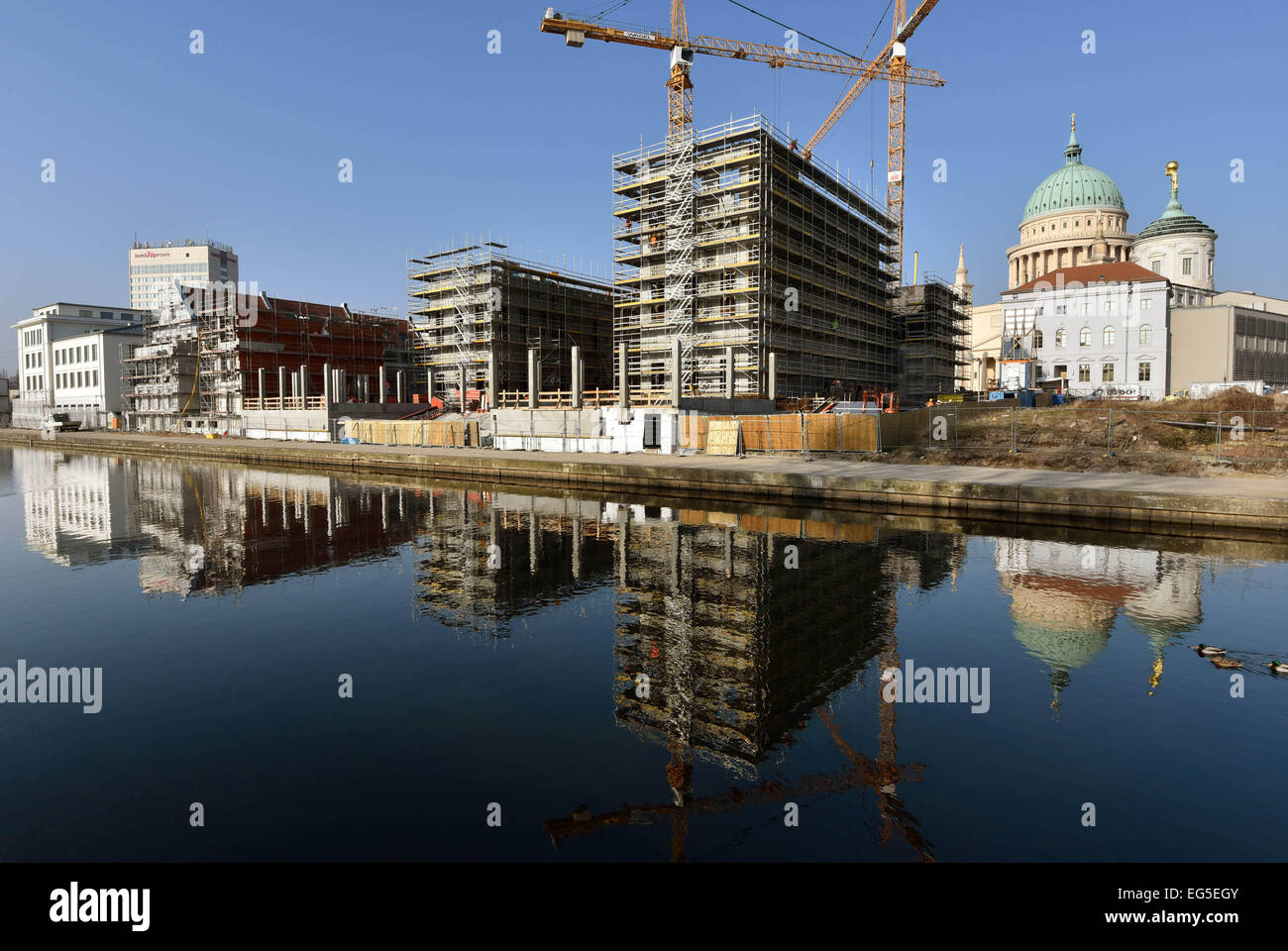 Potsdam, Germany. 17th Feb, 2015. Cranes stand at the construction site of the Palais Barberini at the Alten Fahrt in Potsdam, Germany, 17 February 2015. The building built after the example of the historic palace, will host the art museum of Hasso Plattner. Late 2016 the prestigous building will open with an exhibition of impressionist paintings. PHOTO: BERND SETTNIK/dpa/Alamy Live News Stock Photo
