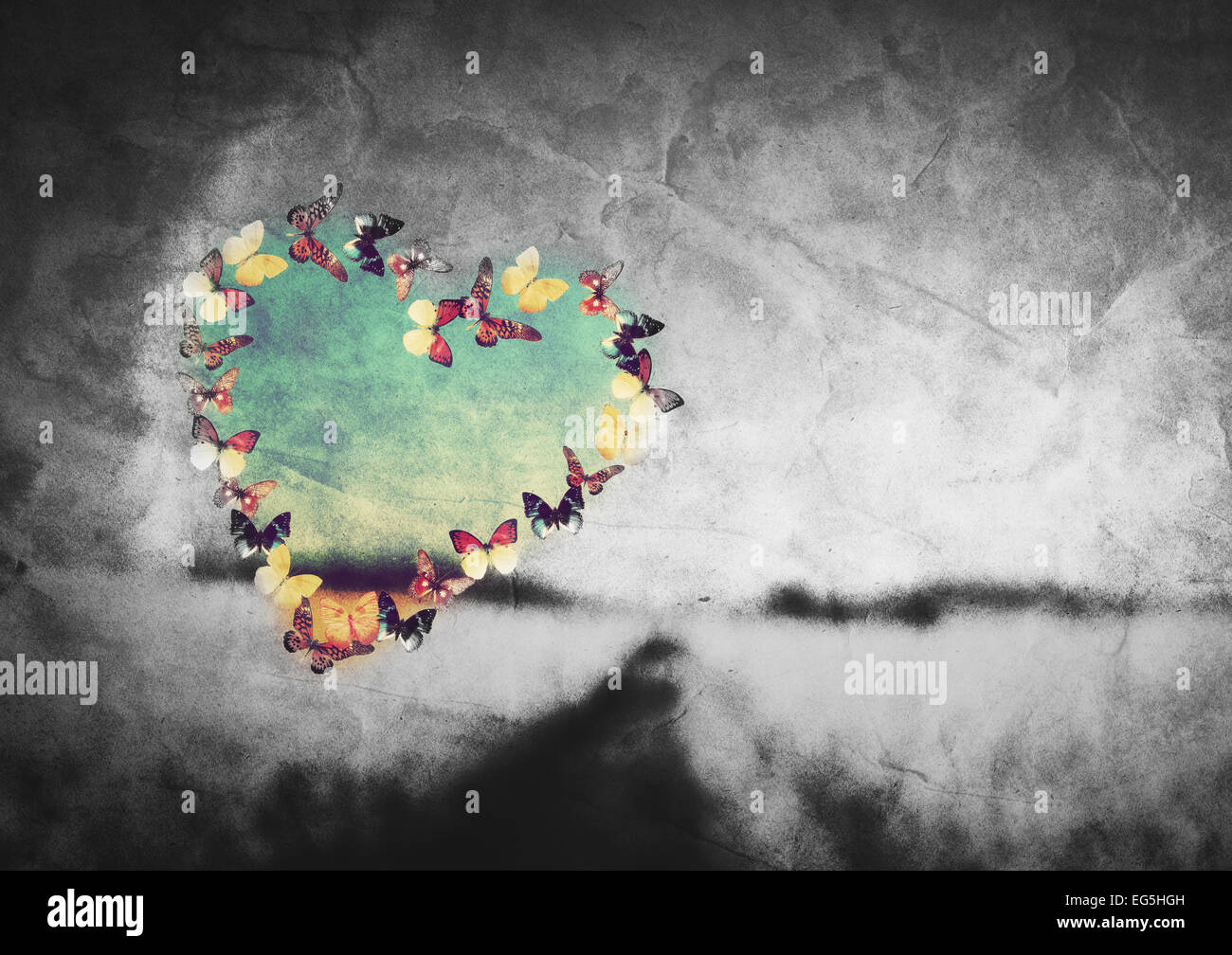 Heart shape made of colorful butterflies on black and white field vintage background. Love, hope concept. Stock Photo