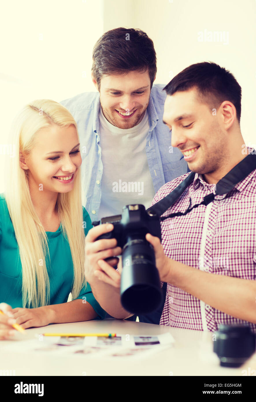 smiling team with photocamera working in office Stock Photo - Alamy